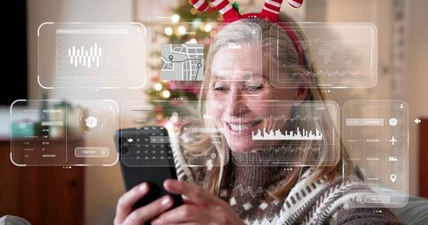 Mature woman using smartphone and viewing augmented reality holiday dashboard at home