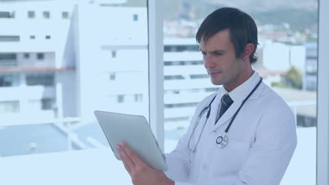 Male Doctor Using Digital Tablet in Hospital Setting