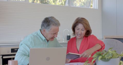 Senior Couple Happily Managing Finances at Home with Tools