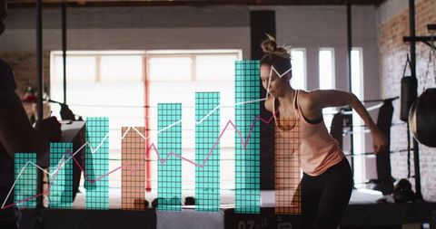 Female athlete performing lateral hop at plyo box with coach tracking performance analytics