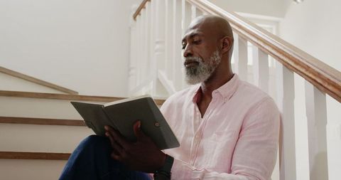 Mature African American Man Reading on Home Staircase