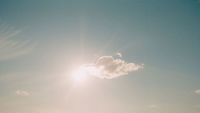 Cumulus cloud illuminated by radiant sun in serene sky