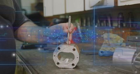 Mechanic analyzing cylinder head with pick tool in workshop