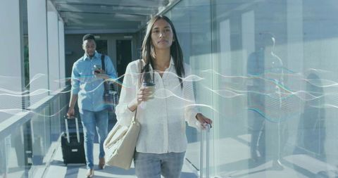 Business travelers strolling through airport with luggage