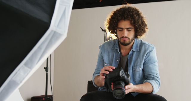 Photographer Reviewing Shots in Studio with Professional Camera - Download Free Stock Images Pikwizard.com