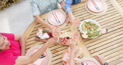 Senior Friends Enjoying Outdoor Meal with Toasting and Healthy Food