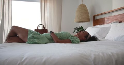 Relaxation at Home: Peaceful Woman Rejuvenating in Scandi-Inspired Bedroom