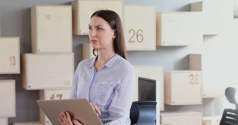 Focused Businesswoman Holding Laptop Analyzing Work Data