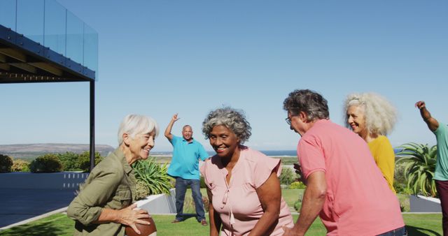 Group of senior friends enjoying a fun game of catch outside on a sunny day. Perfect for depicting active senior lifestyle, health and wellness in retirement, or the importance of social connections in older age.