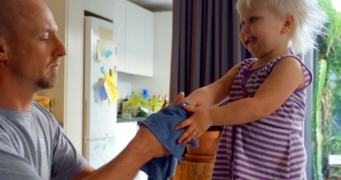 Father Wiping Toddler's Hands at Home