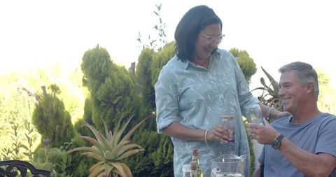 Diverse couple enjoying refreshing drink on sunny patio