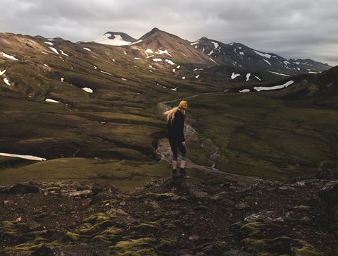 Woman Hiking Through Raw Landscapes of Icelandic Mountains