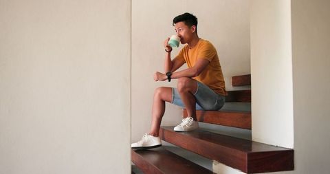 Man relaxing with coffee on modern floating staircase