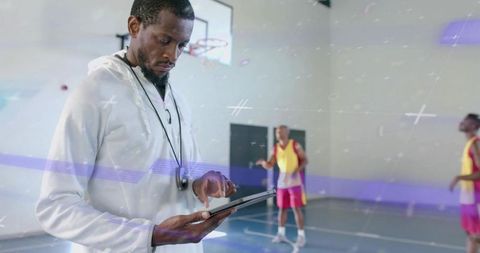 Basketball Coach Reviewing Tablet During Training Session