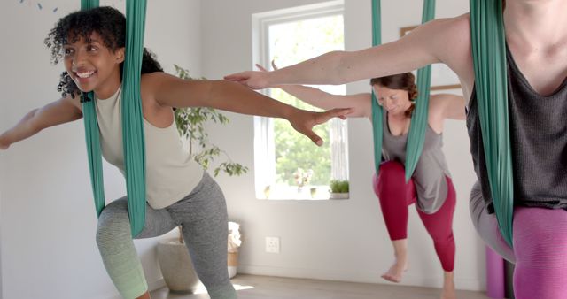 Diverse Women Practicing Aerial Yoga Poses in Studio Environment - Download Free Stock Images Pikwizard.com