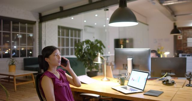 Businesswoman Communicating on Phone in Modern Office at Night - Download Free Stock Images Pikwizard.com