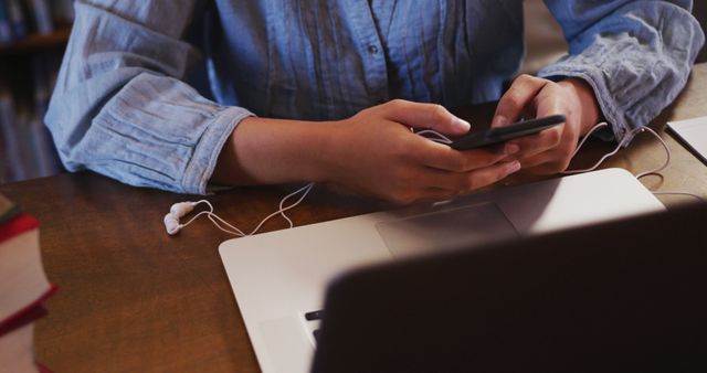 Person Using Smartphone While Working on Laptop in Office - Download Free Stock Images Pikwizard.com