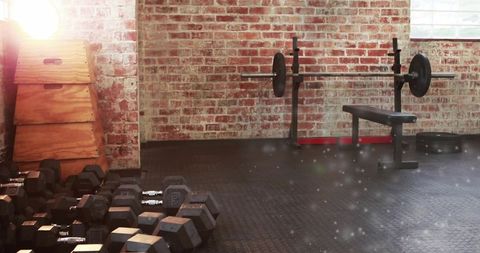 Garage gym featuring hex dumbbells, bench press and plyo box against rustic brick wall