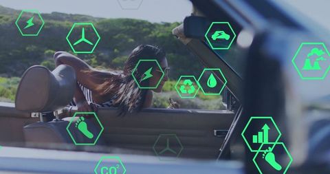 Woman in convertible encountering digital green sustainability icons