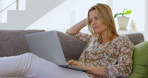 Relaxed Woman Working on Laptop at Home in Bright Living Room