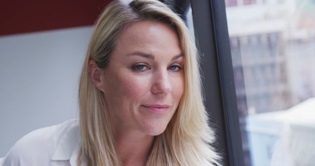 Confident Businesswoman Smiling at Office Window - Download Free Stock Images Pikwizard.com