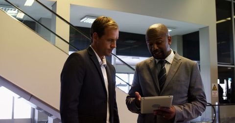 Business Professionals Collaborating at Airport with Tablet