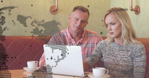 Colleagues Collaborating on Laptop in Cafe with Global Network Overlay