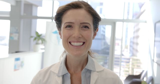 Smiling Female Doctor Radiating Confidence in Modern Medical Office - Download Free Stock Images Pikwizard.com