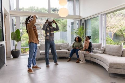 African American Friends Exploring Virtual Reality in Bright Modern Living Room
