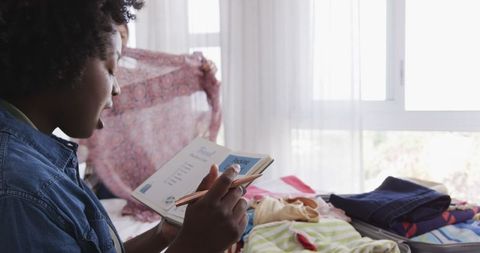 Couple Packing for Summer Vacation and Making Checklist at Home