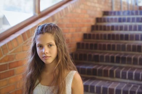 Teenager Standing by Brick Staircase in Natural Light