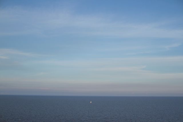 Calm Blue Sea with Sailboat on the Horizon Under Clear Sky - Download Free Stock Photos Pikwizard.com