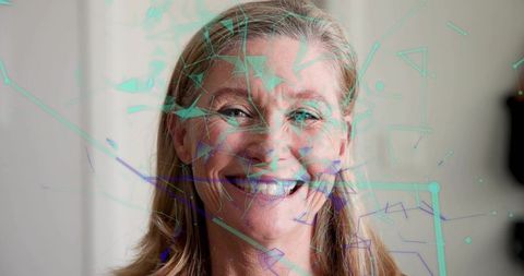 Smiling senior woman wearing pale blouse with teal purple geometric data overlay headshot
