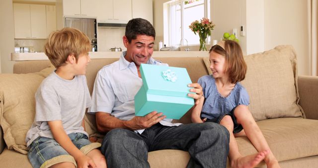 Father with Children Excitedly Opening Gift Box in Living Room - Download Free Stock Images Pikwizard.com