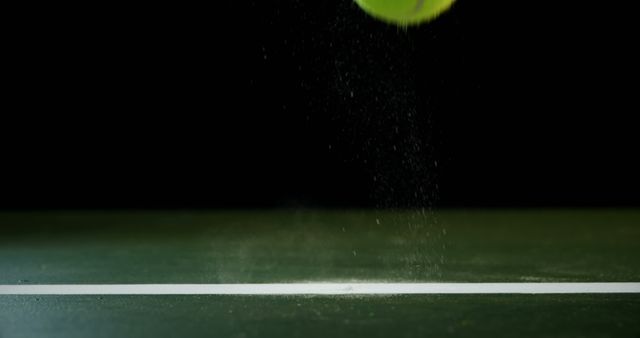 Tennis ball captured in mid-air as it strikes the court line, highlighting motion and speed. Ideal for sports-themed materials, tennis equipment promotions, or dynamic designs emphasizing precision and athleticism.