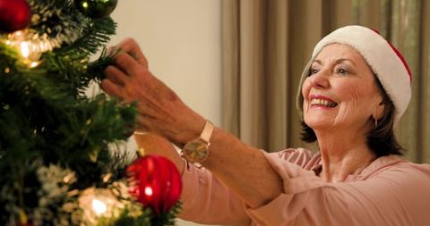 Senior Woman Decorating Christmas Tree with Joyful Spirit