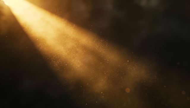 Golden sunbeam revealing dust motes in dim interior with warm bokeh and lens flare