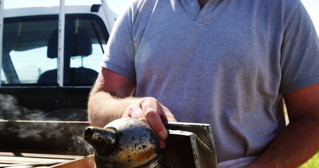 Man Handling Bee Smoker Outdoors in Sunlight - Download Free Stock Images Pikwizard.com