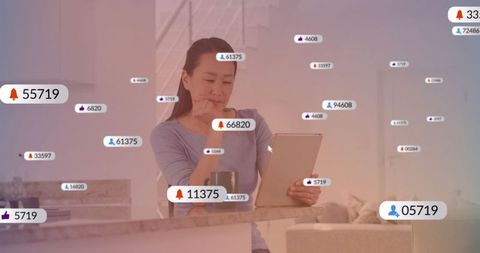 Asian Woman Engaging with Digital Tablet Flooded with Notifications