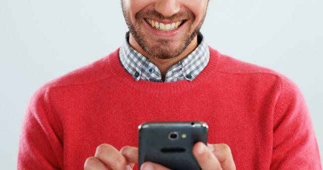 Smiling Man in Red Sweater Using Smartphone - Download Free Stock Images Pikwizard.com