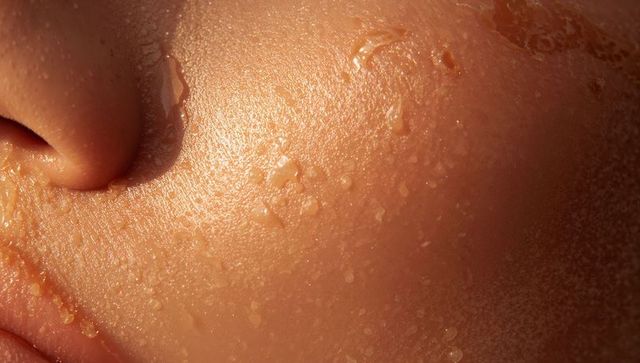 Macro dewy cheek and nostril showing visible pores and sweat droplets, glossy texture