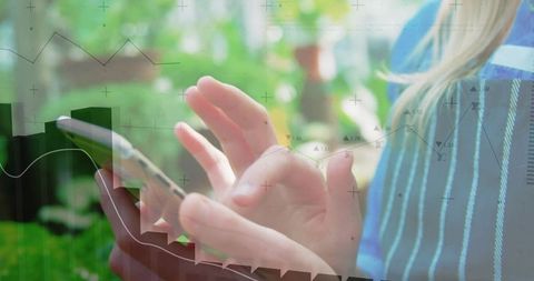 Woman tapping smartphone in garden with data analytics overlay and charts