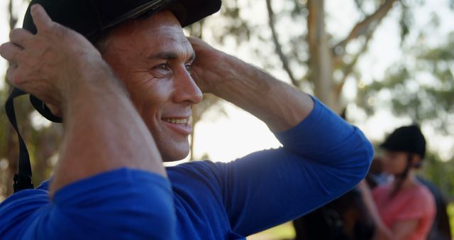 Smiling Man Adjusting Helmet for Outdoor Activity - Download Free Stock Images Pikwizard.com