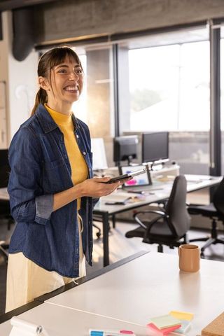 Professional Woman Holding Smartphone in Modern Office Setting