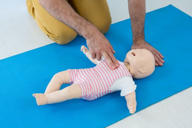 Paramedic practicing infant CPR on a dummy, demonstrating life-saving techniques in a clinical setting. Useful for illustrating medical training, emergency response, pediatric care, and first aid education.