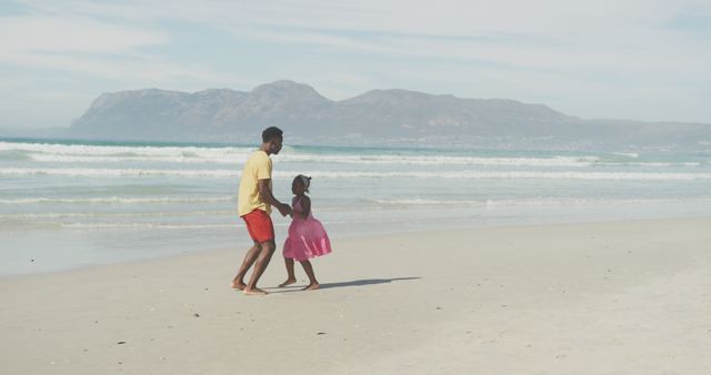 African american father and daughter holding hands jumping at the beach - Download Free Stock Photos Pikwizard.com