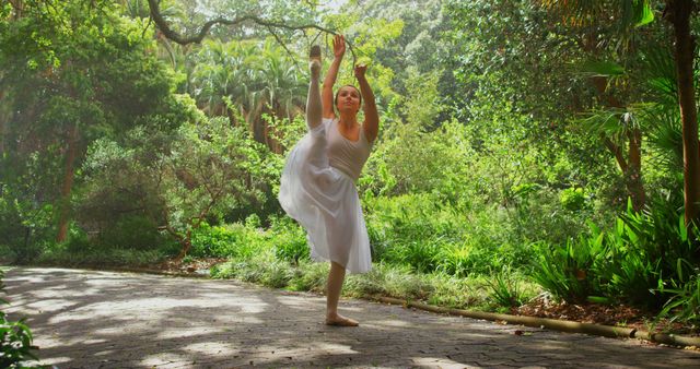 Young ballerina dancing in the park. Dancing gracefully ona sunny day amidst green trees 4k