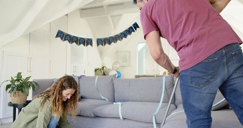 Couple Tidying Up After Birthday Party in Living Room