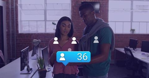 Colleagues collaborating over smartphone showing 36 new contacts in modern office