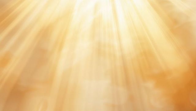 Golden Sunbeams Streaming Through Hazy Sky with Soft Bokeh Glow and Rays